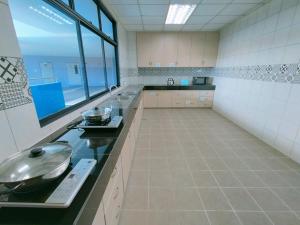 a large kitchen with a sink and a counter at Agape Hostel in Sibu