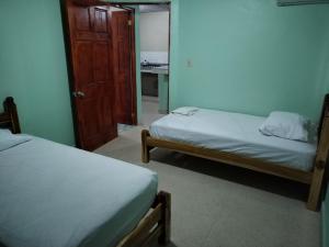 a room with two beds and a door to a bedroom at La Casa Buena Esperanza in Penonomé