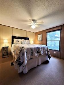 Schlafzimmer mit einem Bett und einem Deckenventilator in der Unterkunft Kayaks, Fishing, Waterfront Cabin and Private Dock in Sneads Ferry