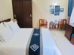 Un dormitorio con una cama con una cinta azul. en Aloha Bình Tiên-Thôn Bình Tiên, Công Hải, Thuận Bắc, Ninh Thuận, Việt Nam, en Phan Rang