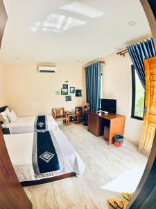 Habitación de hotel con 2 camas y escritorio en Aloha Bình Tiên-Thôn Bình Tiên, Công Hải, Thuận Bắc, Ninh Thuận, Việt Nam, en Phan Rang