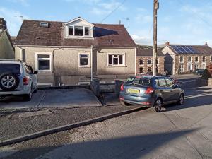 two cars parked on the street in front of a house at Bradford House in Garnant