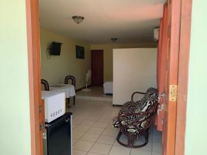 un couloir avec une chambre dotée d'une table et de chaises dans l'établissement Open house, à Managua