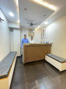 two men standing behind a counter in a hospital room at Vishwanath Inn in Varanasi