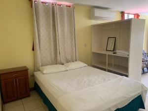 a small bedroom with a bed and a dresser at Open house in Managua