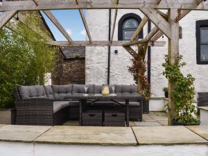 a patio with a couch and a table at Swinside Cottage in Ennerdale Bridge