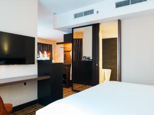 um quarto de hotel com uma cama e uma televisão de ecrã plano em Stay Collection Bukit Bintang em Kuala Lumpur