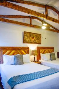 two beds in a room with wooden beams at Hotel Casa Pino, Tu Casa en Ataco in Concepción de Ataco