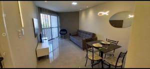 sala de estar con mesa y sofá en Victory Flat Intermares Cabedelo, en Cabedelo