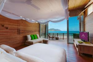 a bedroom with a bed and a view of the ocean at Six Senses Con Dao - Turtle Island Paradise in Con Dao