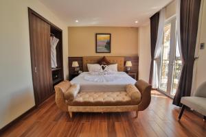 een slaapkamer met een bed en een stoel erin bij Dalat Paradise Hotel in Da Lat