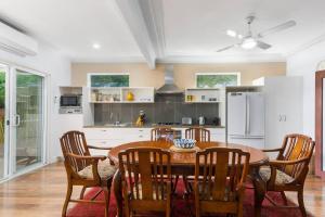 a kitchen with a wooden table and wooden chairs at Ocean Blue Escape - Beachside Living & Granny Flat in Wollongong