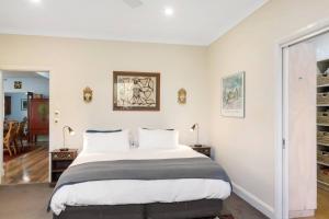 1 dormitorio con 1 cama grande y paredes blancas en Ocean Blue Escape - Beachside Living & Granny Flat en Bellambi