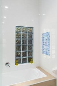 a bathroom with a bath tub and a window at Ocean Blue Escape - Beachside Living & Granny Flat in Wollongong +29 photos