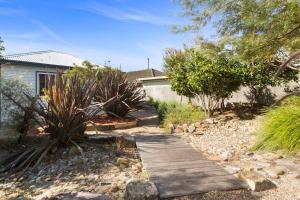 a garden with a wooden walkway in a yard at Ocean Blue Escape - Beachside Living & Granny Flat in Wollongong