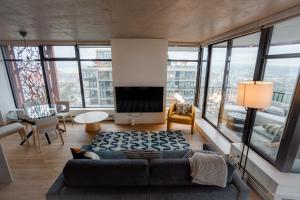 a living room with a couch and large windows at 34th-Floor Gastown 2BR with Parking & Harbour Views in Vancouver