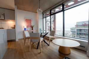 a kitchen and living room with a table and chairs at 34th-Floor Gastown 2BR with Parking & Harbour Views in Vancouver