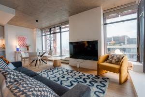 a living room with a couch and a tv at 34th-Floor Gastown 2BR with Parking & Harbour Views in Vancouver