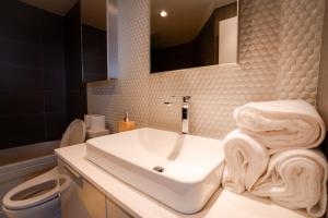 a bathroom with a white sink and a toilet at 34th-Floor Gastown 2BR with Parking & Harbour Views in Vancouver +38 photos