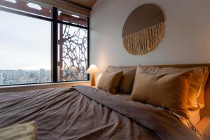 a bedroom with a large bed with a large window at 34th-Floor Gastown 2BR with Parking & Harbour Views in Vancouver