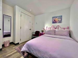 a bedroom with a large bed with a pink headboard at Apartment Studio with Shared Bathroom on the 1st Floor 10 minutes walk to University of WA in Seattle