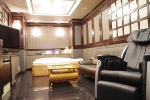 東京にあるHotel PRINCESS2 大人専用のベッド、ソファ、テレビが備わる客室です。