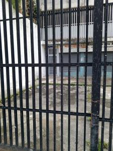 a black fence with a pole in front of a building at Como en Casa in Caracas