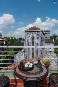a balcony with a table and a church at Cheers Hostel Hanoi in Hanoi