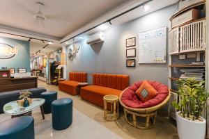 a waiting room with orange and blue furniture at Cheers Hostel Hanoi in Hanoi