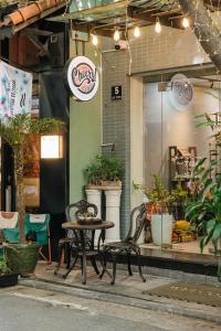 a table and chairs in front of a store at Cheers Hostel Hanoi in Hanoi