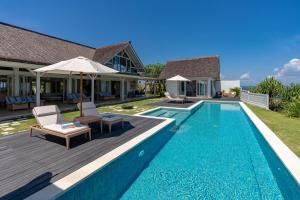 a villa with a swimming pool and a house at Casa del Mar in Nusa Lembongan