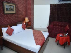 a bedroom with a bed and a red couch at Luxury one hotel Lahore in Lahore