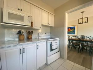 eine Küche mit weißen Schränken und einer Mikrowelle in der Unterkunft Private Room Lakeview House- Westmount in Moncton