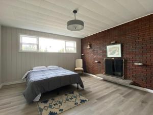 ein Schlafzimmer mit einem Bett und einer Ziegelwand in der Unterkunft Private Room Lakeview House- Westmount in Moncton
