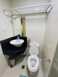 een badkamer met een toilet en een wastafel bij Vevilyn Condotel in Manilla