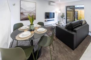 a living room with a table and a couch at An Easy Walk to the CBD - 2 Bed, 2 Bathroom in Christchurch