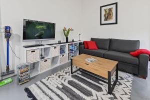 a living room with a couch and a tv at Parsons Flat River Barn in Dargo
