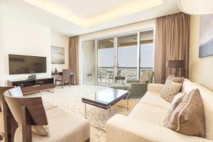 een woonkamer met een bank, een tafel en een televisie bij Address Dubai Mall Exclusive in Dubai
