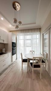 - une cuisine et une salle à manger avec une table et des chaises dans l'établissement Luxe Appartments on Stepnoy, à Karaganda