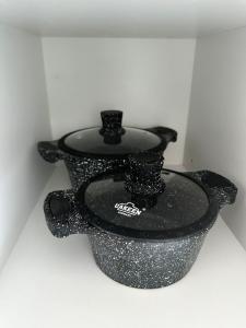 two black vases are sitting on a wall at Luxe Appartments on Stepnoy in Karagandy