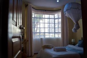 a bedroom with two beds and a large window at Madiniplace 1 - Flexible 1-3BR Apartment near JKIA & SGR in Nairobi +20 photos