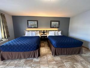 2 bedden in een hotelkamer met blauwe lakens bij Coastal Bend at Seadrift, Motel & RV Park in Seadrift