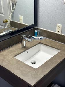 een witte wastafel in een badkamer met een spiegel bij Coastal Bend at Seadrift, Motel & RV Park in Seadrift