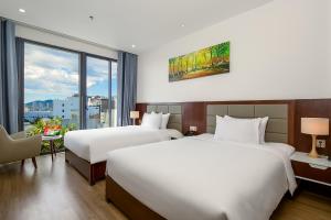 um quarto de hotel com duas camas e uma janela em Aria Grand Hotel & Spa em Da Nang