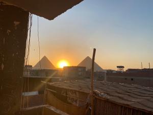 a view of the pyramids at sunset from a building at Zein Pyramids View - Guest House in Cairo