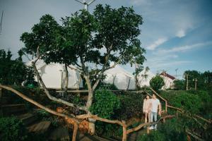 a group of three people standing next to a tree at Cloud9 Glamping & Cafe in Xuân Trường