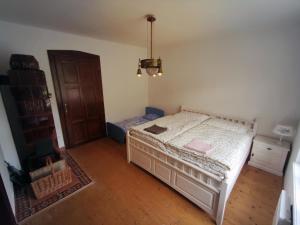 een slaapkamer met een wit bed en een houten vloer bij CHALUPA NAD POTOKEM in Zlaté Hory