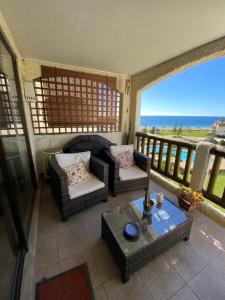 a living room with a balcony with a view of the ocean at Departamento Papudo Condominio Punta Fundadores in Papudo