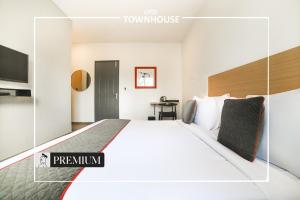 a hotel room with a large bed and a tv at Super Townhouse Boutique Hotel 242 Sarjapur Road in Bangalore