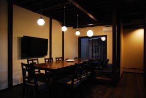 una sala da pranzo con tavolo, sedie e luci di 金沢一棟宿 海泉 Restoring In Kanazawa KAISEN a Kanazawa